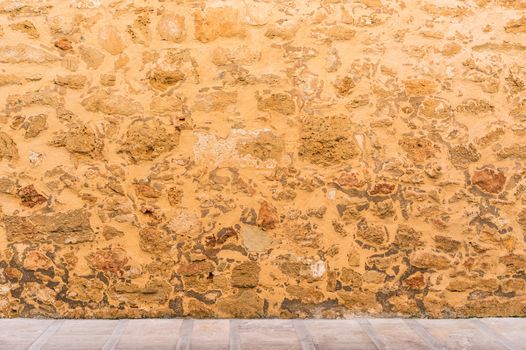 Vintage stone wall background texture with pavement