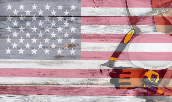 Labor Day concept with industrial worker tools over distressed white wooden boards with see through US Flag 