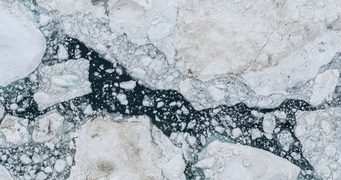 Icebergs drone aerial photo top view - Climate Change and Global Warming - Icebergs from melting glacier in icefjord in Ilulissat, Greenland. Arctic nature ice landscape in Unesco World Heritage Site.