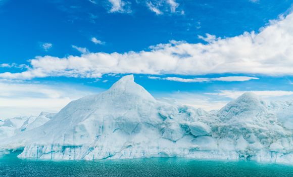 Global warming - Greenland Iceberg landscape of Ilulissat icefjord with giant icebergs. Icebergs from melting glacier. Arctic nature heavily affected by climate change