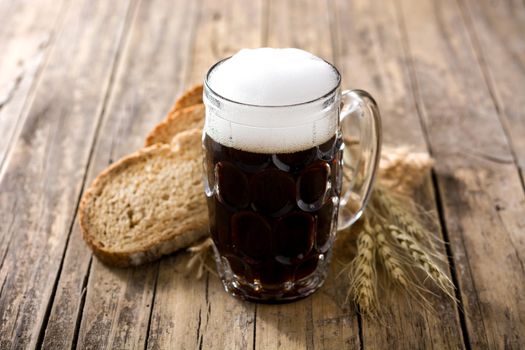 Traditional kvass beer mug with rye bread on wooden table