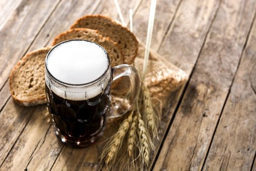 Traditional kvass beer mug with rye bread on wooden table