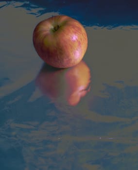 Apple on silver ground, reflections, red