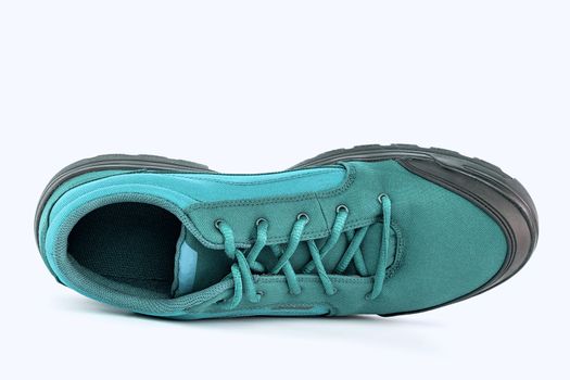 right cheap turquoise fabric hiking or hunting shoe isolated on white background, view from top or laid on side
