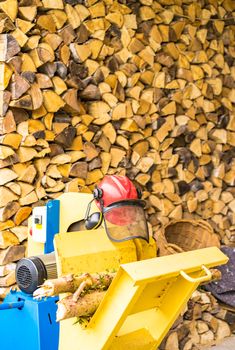 Circular saw in front of a firewood stack