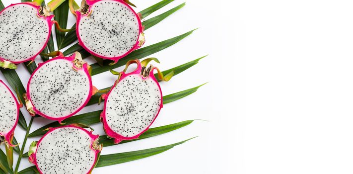 Ripe dragonfruit or pitahaya on tropical palm leaves. Copy space