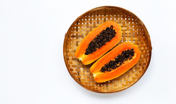 Papaya on wooden bamboo threshing basket on white background. Copy space