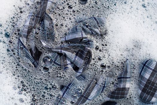 Top view of clothes soak in powder detergent water dissolution. Laundry concept