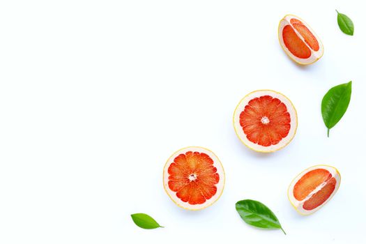 High vitamin C. Juicy grapefruit slices with green leaves on white background. Copy space