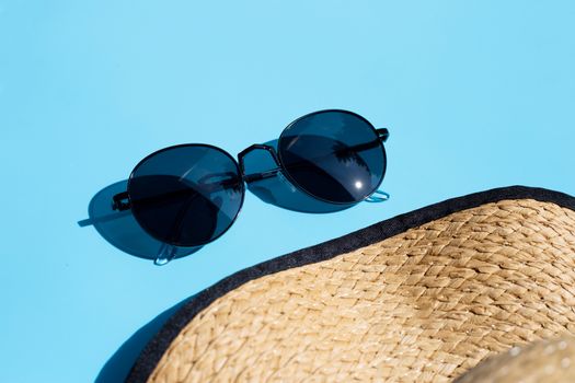 Sunglasses with summer hat on blue background. Enjoy holiday concept. Copy space