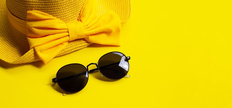 Sunglasses with summer hat on yellow background. Enjoy holiday concept. Copy space