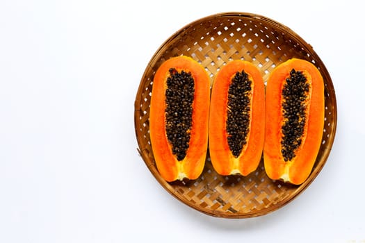Ripe papaya fruit in wooden bamboo threshing basket on white background. Copy space