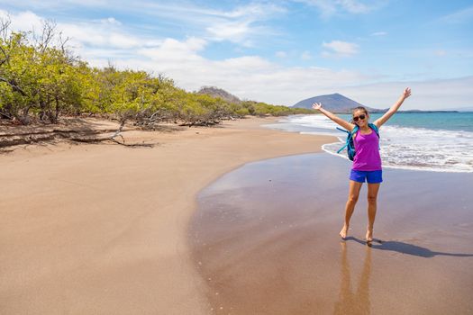 Galapagos tourist having fun on travel on Espumilla Beach, Santiago Island, Galapagos Islands, Ecuador.
