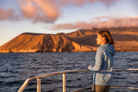 Cruise ship tourist on boat looking at sunset nature landscape in Galapagos Islands.