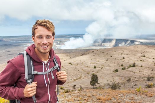 Hawaii volcano tourist man at Halemaumau crater in Kilauea caldera in Hawaii Volcanoes National Park, big Island with volcanic clouds and ash from eruption.