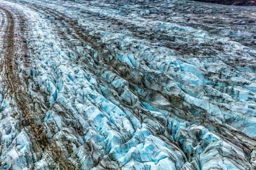 Glacier arm blue ice texture from above. Top aerial view from helicopter ride in Glacier Bay National Park, Alaska, USA. Shore excursion from cruise ship travel vacation.