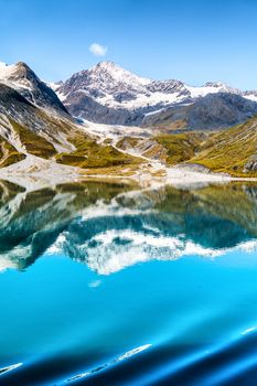 Glacier Bay National Park, Alaska, USA. Amazing glacial landscape view from cruise ship vacation travel showing mountain peaks and glaciers on clear blue sky summer day.