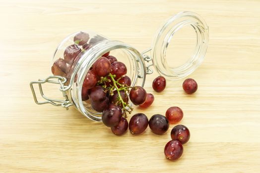 fresh grapes in glass bottle on wood table