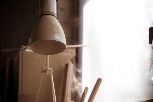 old dusty lamp in carpentry workshop.