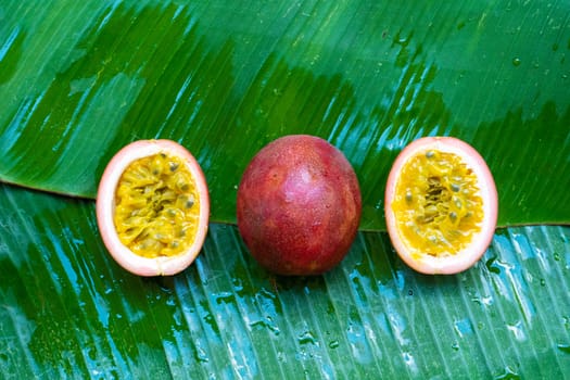 Ripe passion fruit, on a wet banana leaf. Vitamins, fruits, healthy foods.