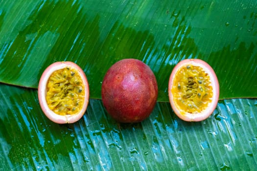 Ripe passion fruit, on a wet banana leaf. Vitamins, fruits, healthy foods.