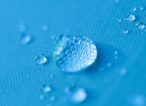 Close-up of a drop of water on a blue background.