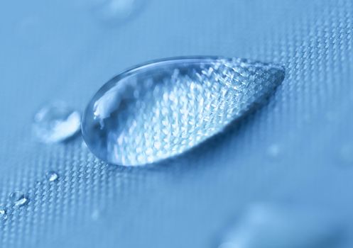 Close-up of a drop of water on a blue background.