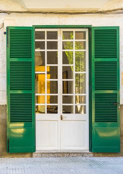 Detail view of elegant mansion door with open green shutters