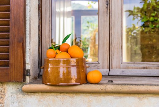 Fresh oranges in fruit bowl on window sill, idyllic still life