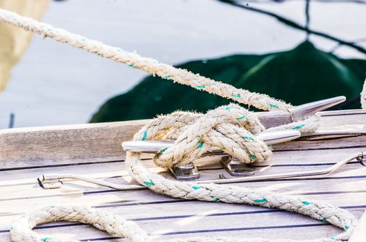 Close-up of cleat and rope on wooden boat deck