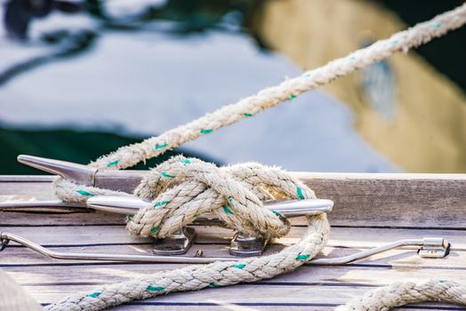 Detail view of yacht rope cleat on sailboat deck

