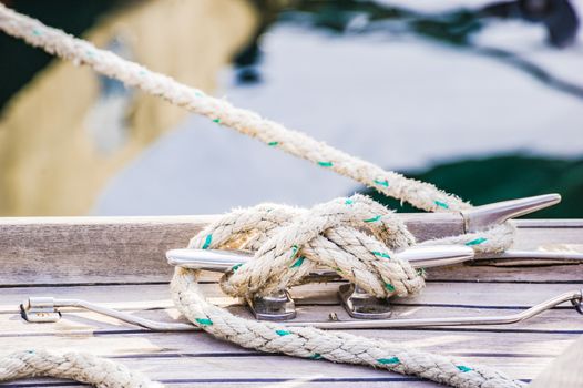 Close-up of cleat and rope on wooden boat deck