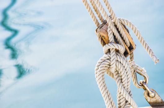 Detail image of wooden pulley with ropes of an classical sailing yacht