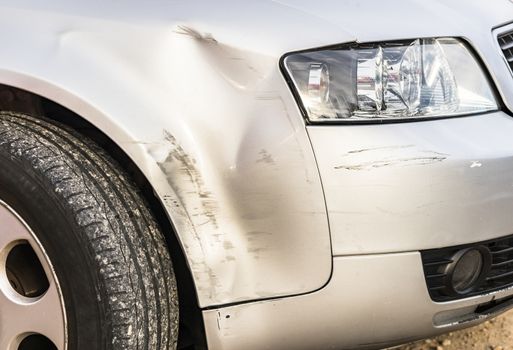 Car accident with close-up of damaged silver bumper 