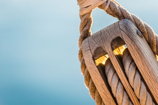 Detail image of wooden pulley with ropes of an classical sailing yacht