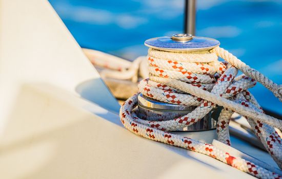 Close-up of winch with nautical rope on boat deck of sailing yacht