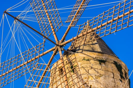 Close-up of old historic windmill wings with blue sky background