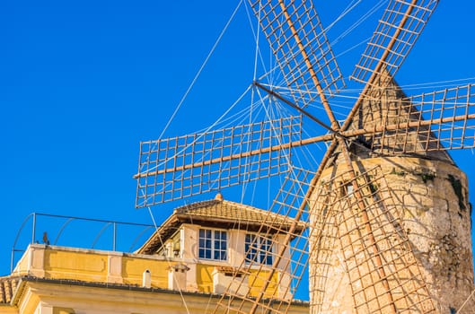 Old historic windmill wings with blue sunny sky background