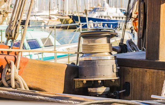 Close-up of winch with nautical rope on boat deck of old sailing yacht