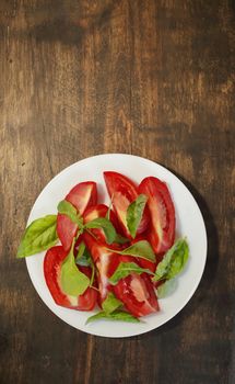 Sliced tomatoes with lettuce on a white plate. Healthy eating concept. High quality photo