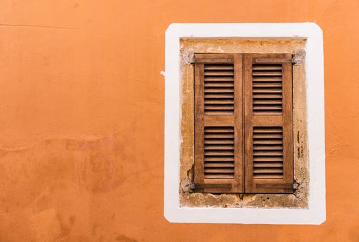 Old mediterranean window shutters and wall background 