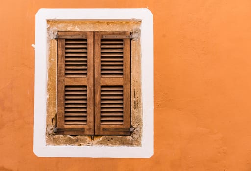 Detail view of wooden brown window shutters and wall