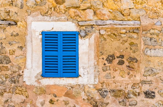 Old mediterranean blue window shutters and stone wall background with copy space 