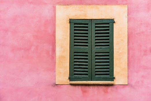 Old mediterranean window shutters and wall background 