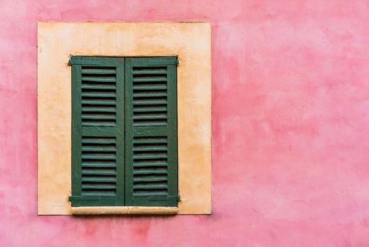 Old mediterranean window shutters and wall background