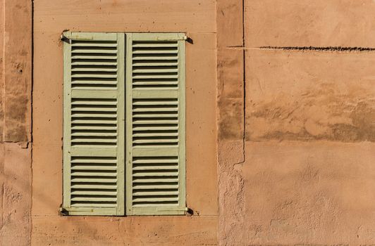Old mediterranean window shutters and wall background 