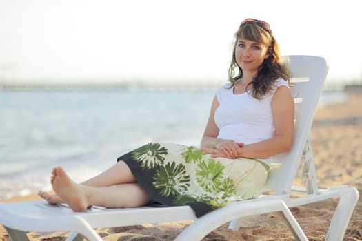 Young woman is relaxing on the beach at the pier. Vacation Travel Concept. High quality photo