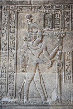 Hieroglypic carvings on wall at the ancient egyptian temple of Khnum in Esna showing god Osiris