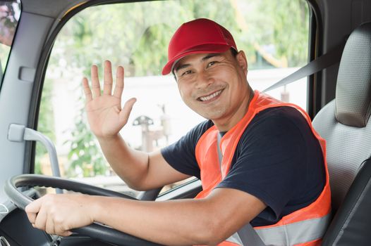 Professional worker truck driver, confident middle-aged Asian man wearing safety clothing Smile proudly In moving forward For a long transportation business