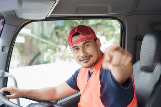 Professional worker truck driver, confident middle-aged Asian man wearing safety clothing Smile proudly In moving forward For a long transportation business
